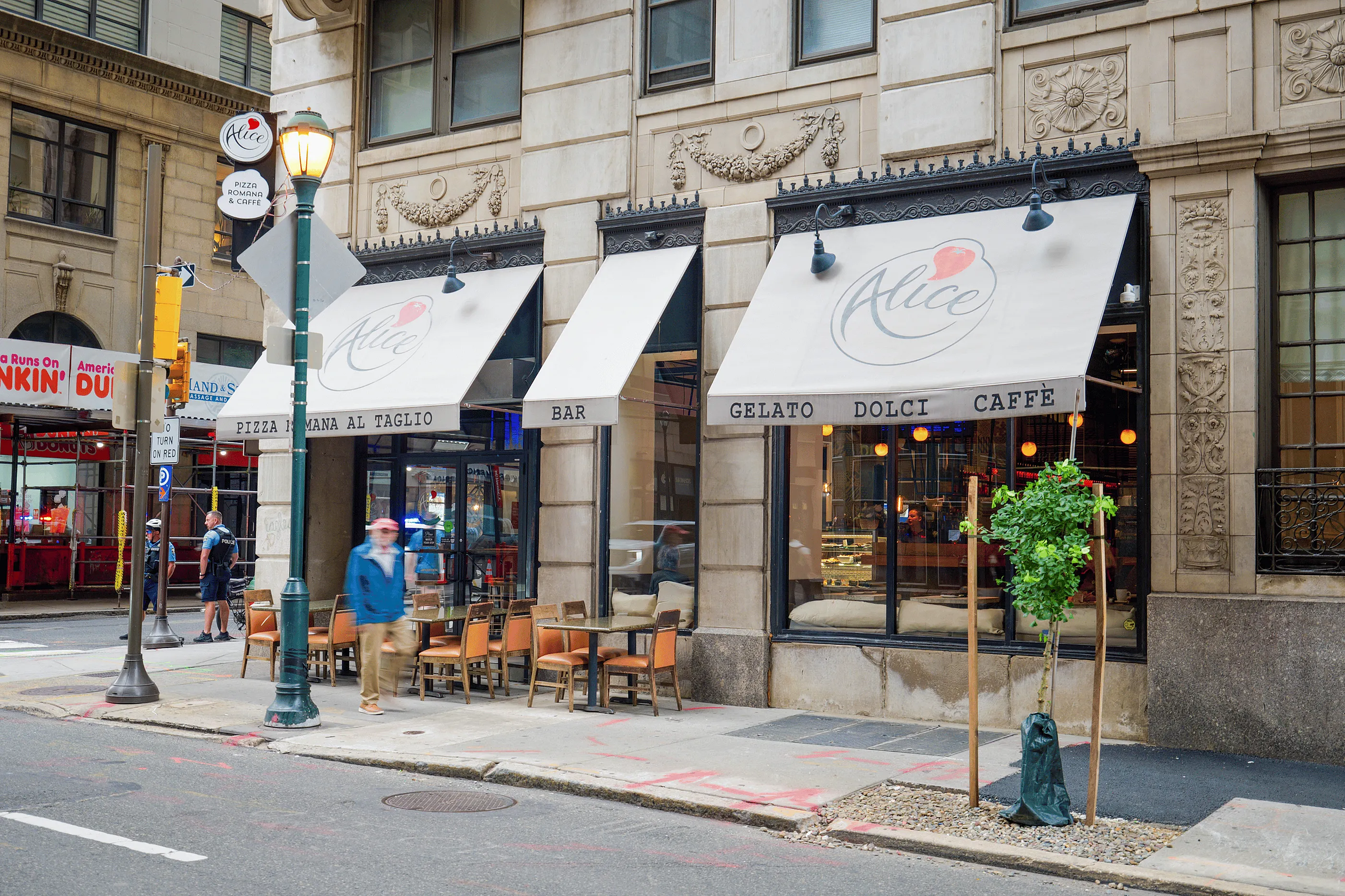 Charming Italian cafe exterior with inviting outdoor seating, featuring stylish awnings and elegant architectural details.