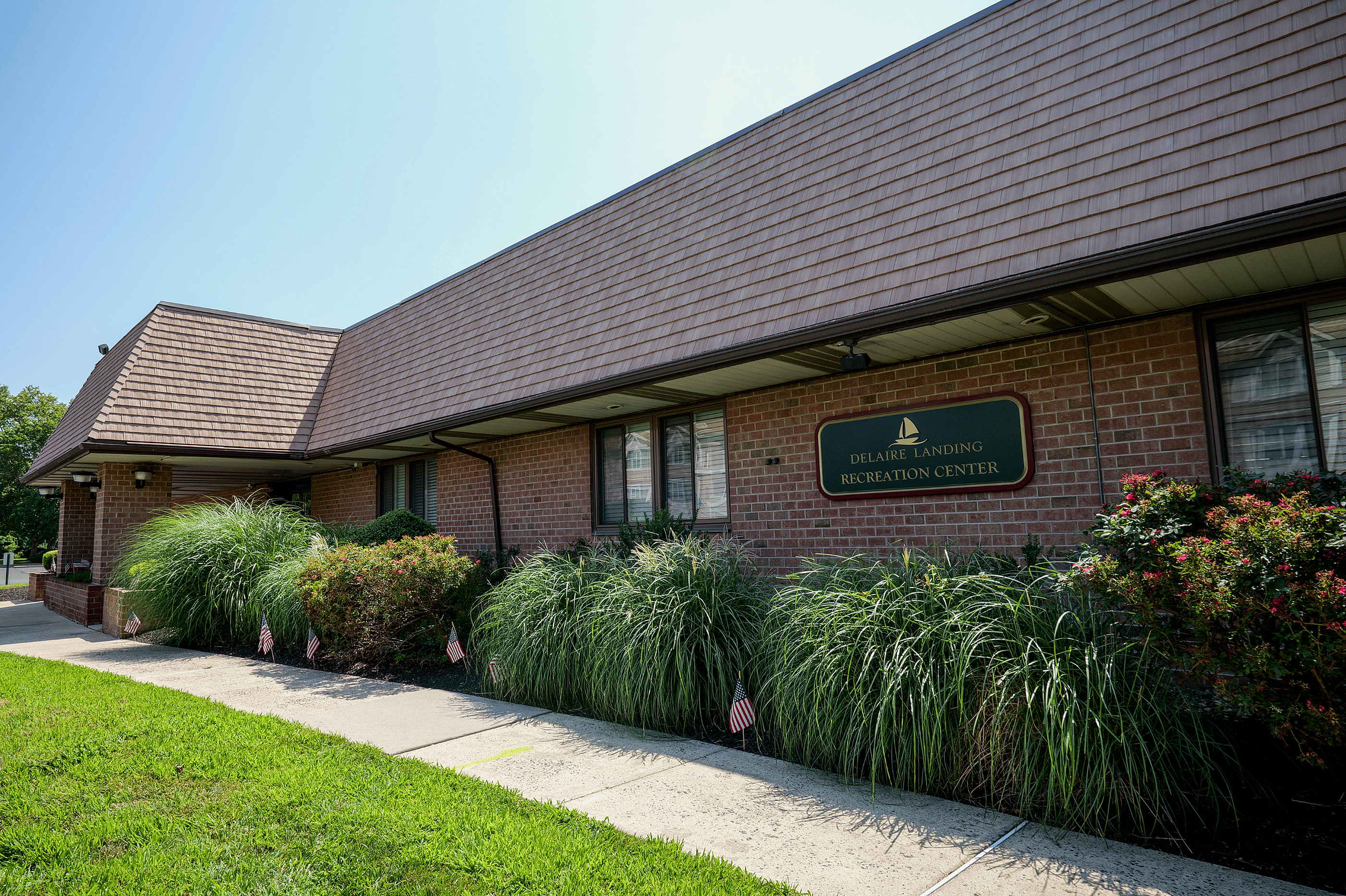 Inviting brick recreation center with lush green landscaping and a welcoming atmosphere.