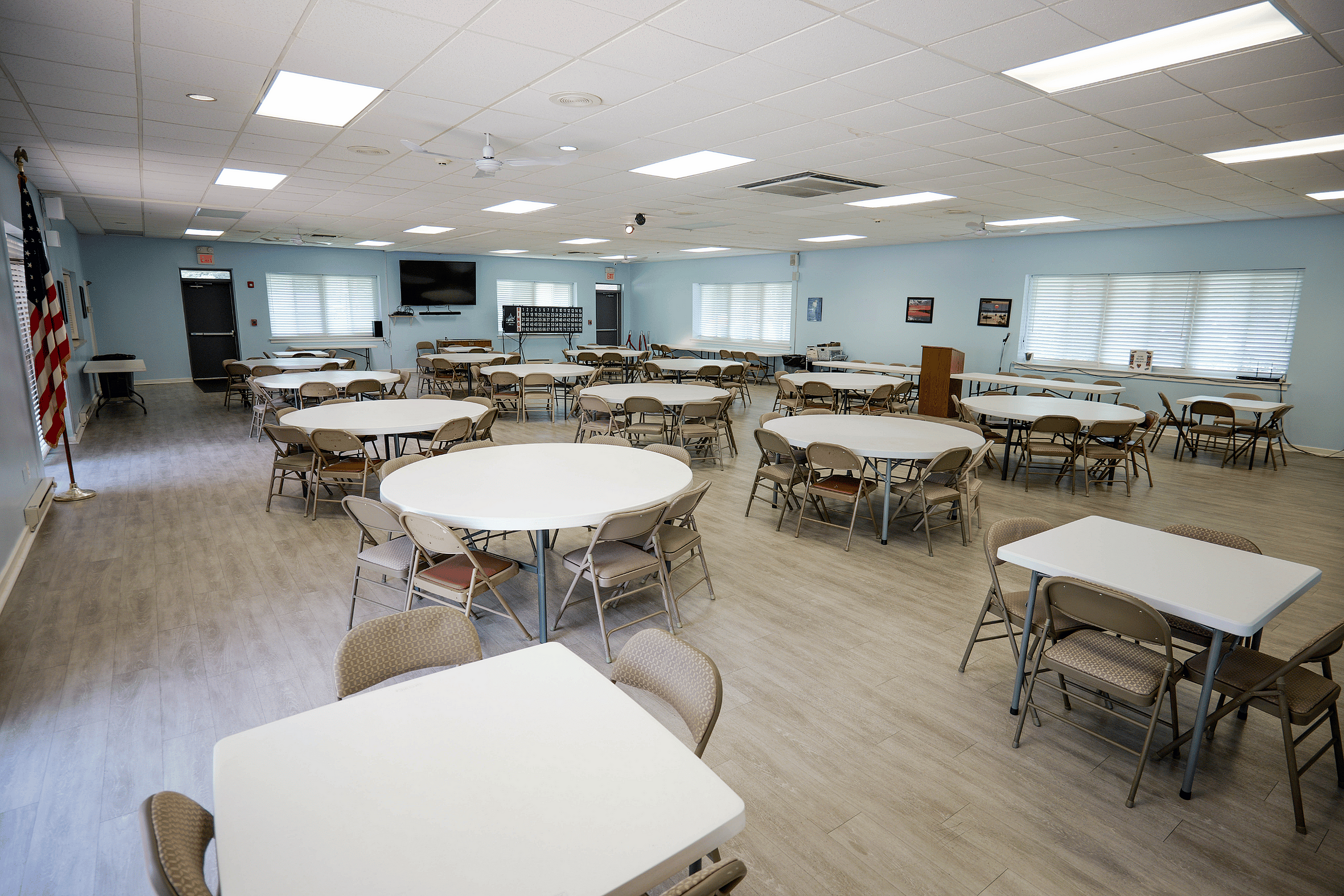 Bright and spacious community room with elegant tables and chairs, perfect for gatherings and events, featuring modern decor and ample natural light.