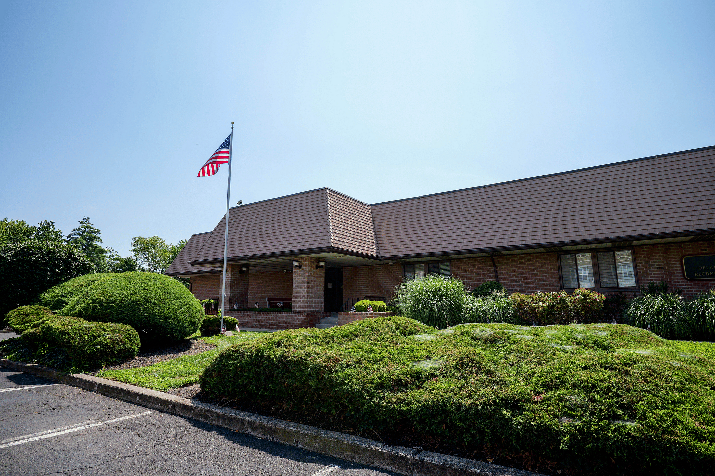 Charming brick building with a well-maintained lawn and an American flag, perfect for community gatherings.