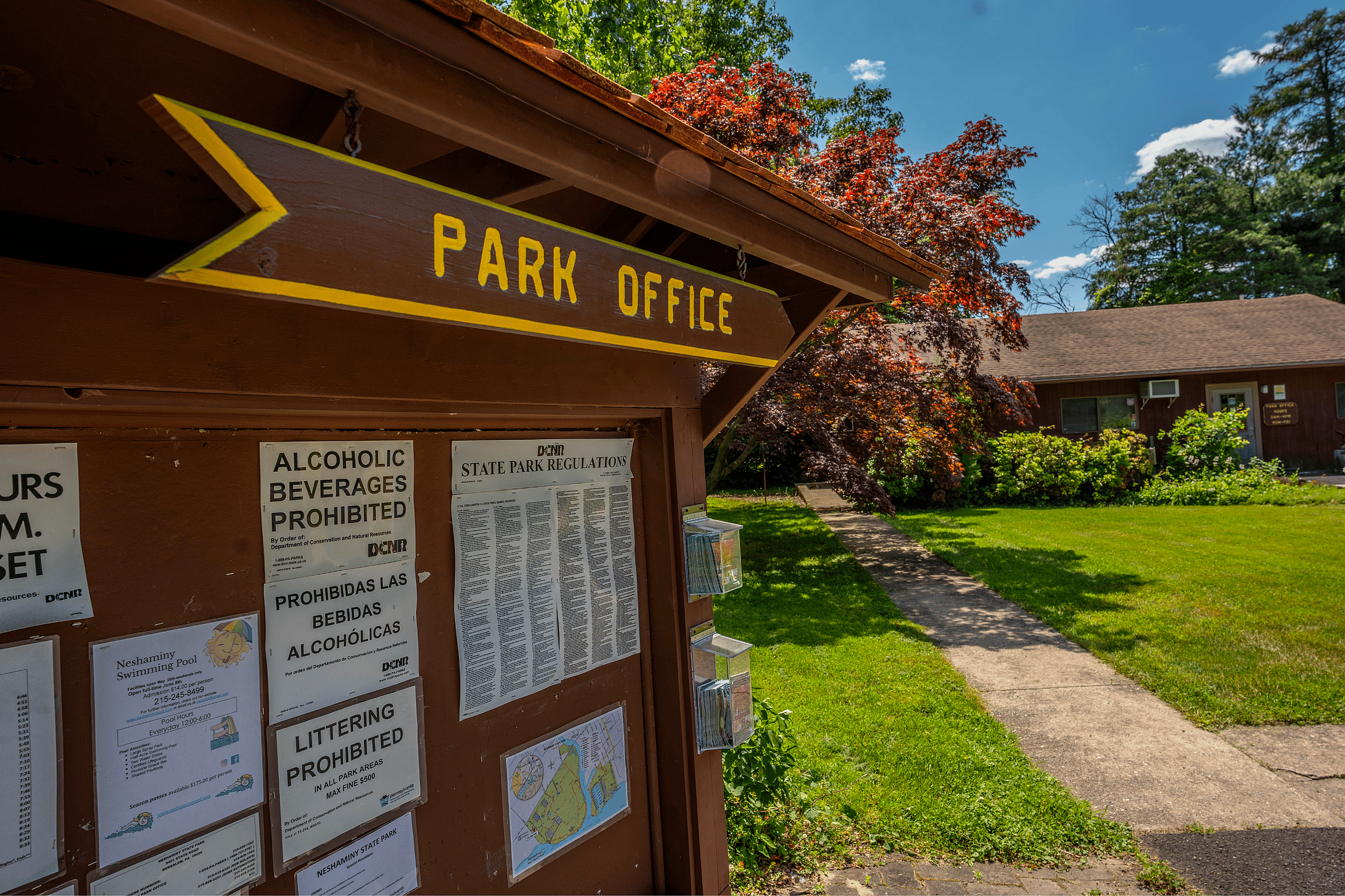 Charming park office with colorful foliage and a bright sunny pathway, inviting natural exploration and relaxation.