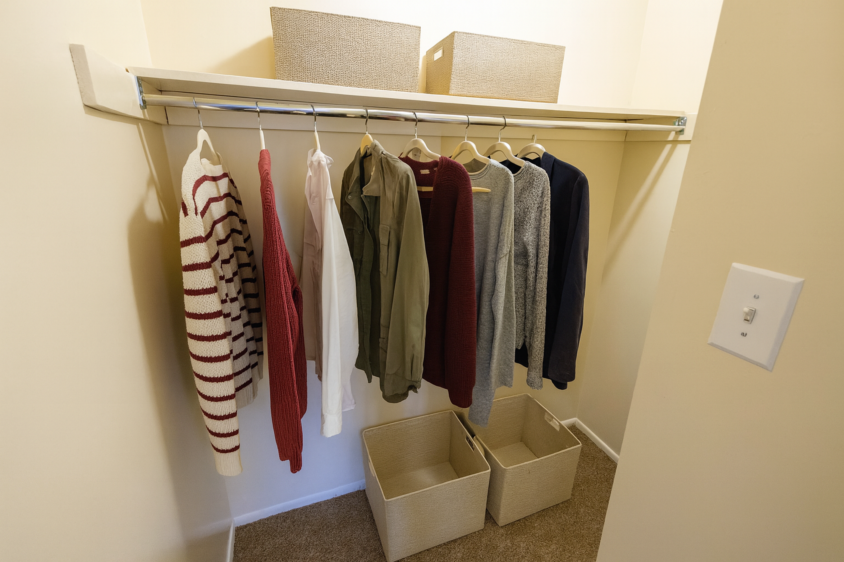 Spacious walk-in closet with organized hanging space and stylish storage baskets, perfect for maximizing bedroom storage.