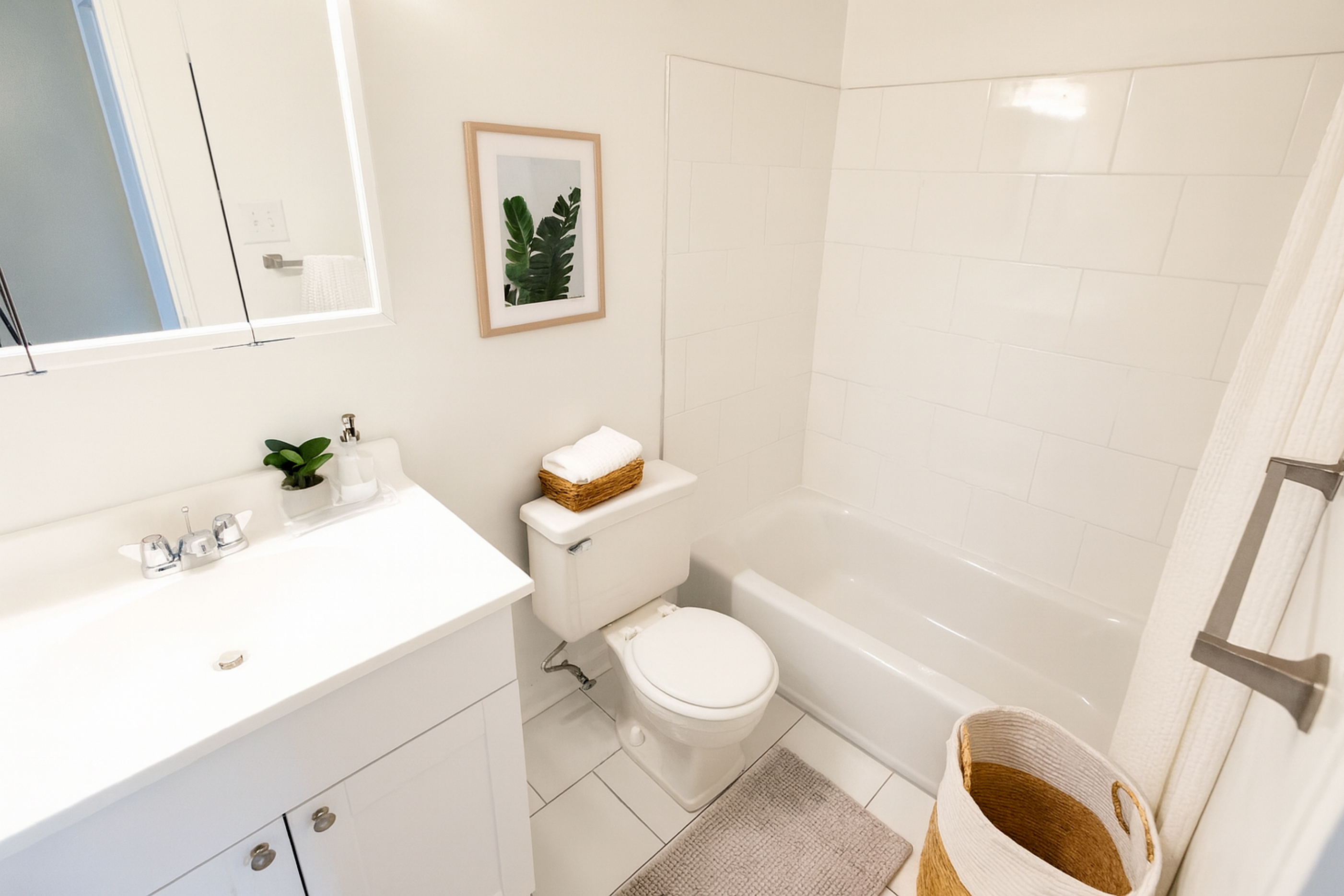 Bright and modern bathroom with sleek fixtures, a bathtub, and stylish decor.