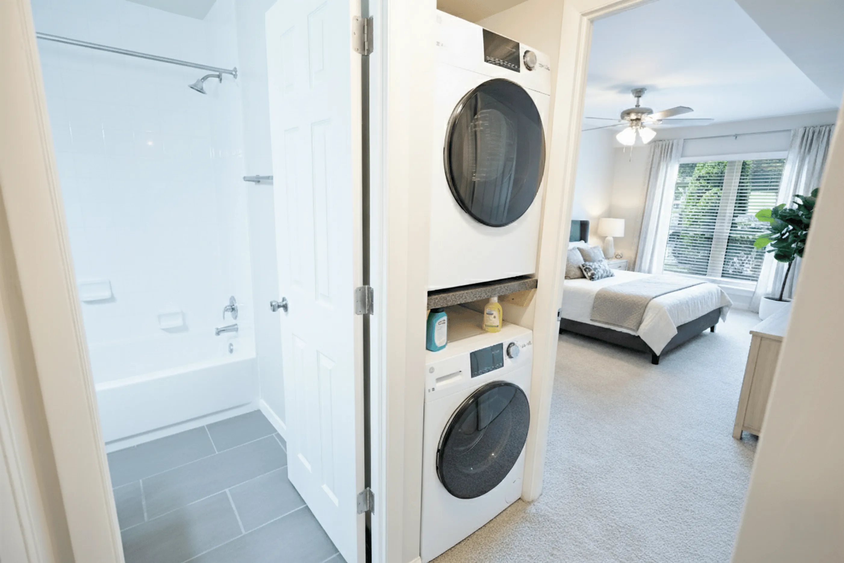 Modern apartment with in-unit washer and dryer, sleek bathroom, and a cozy bedroom with garden views.