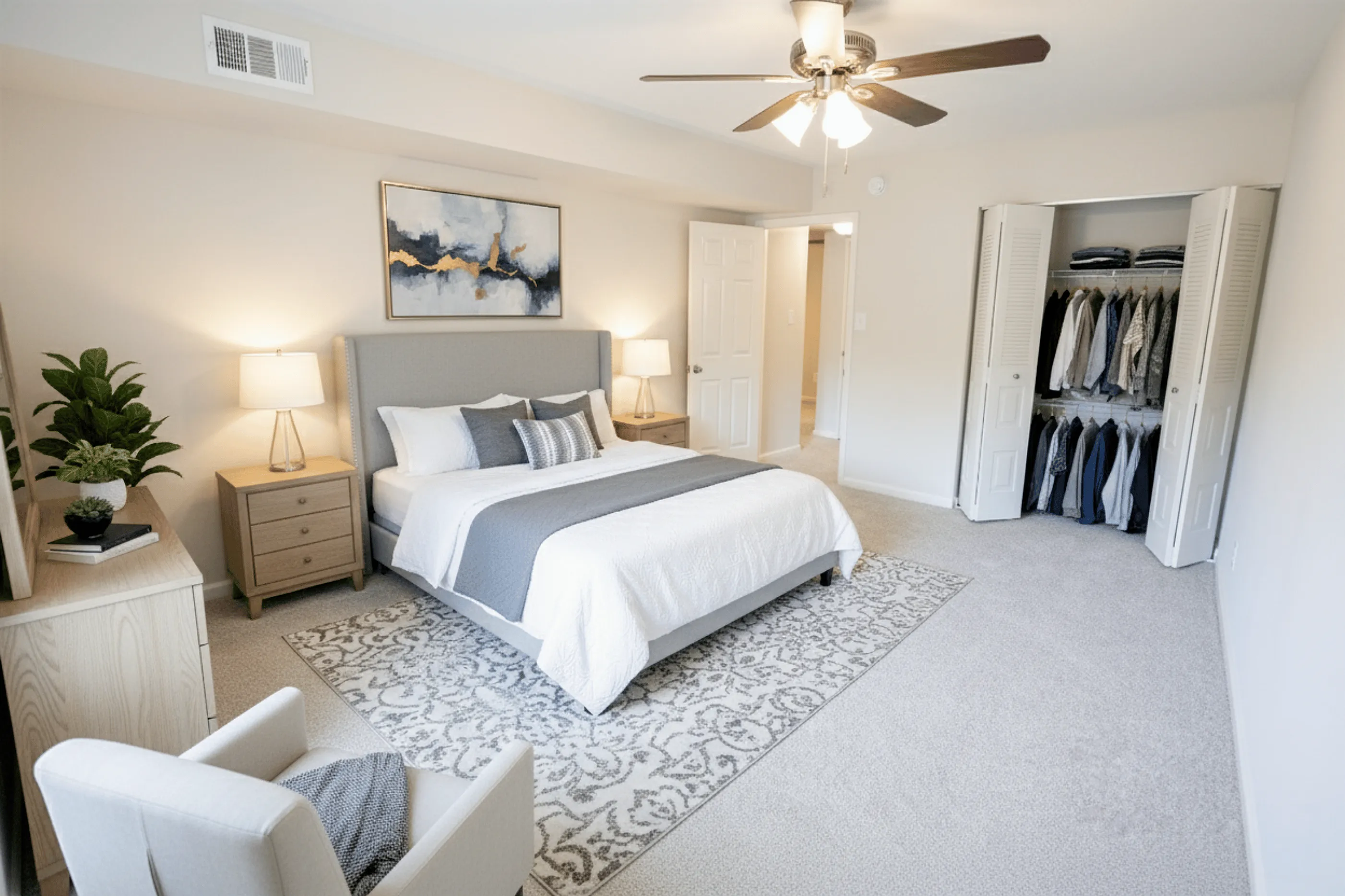 Bright and elegant bedroom featuring a plush bed, stylish artwork, and an organized open closet for a serene retreat.