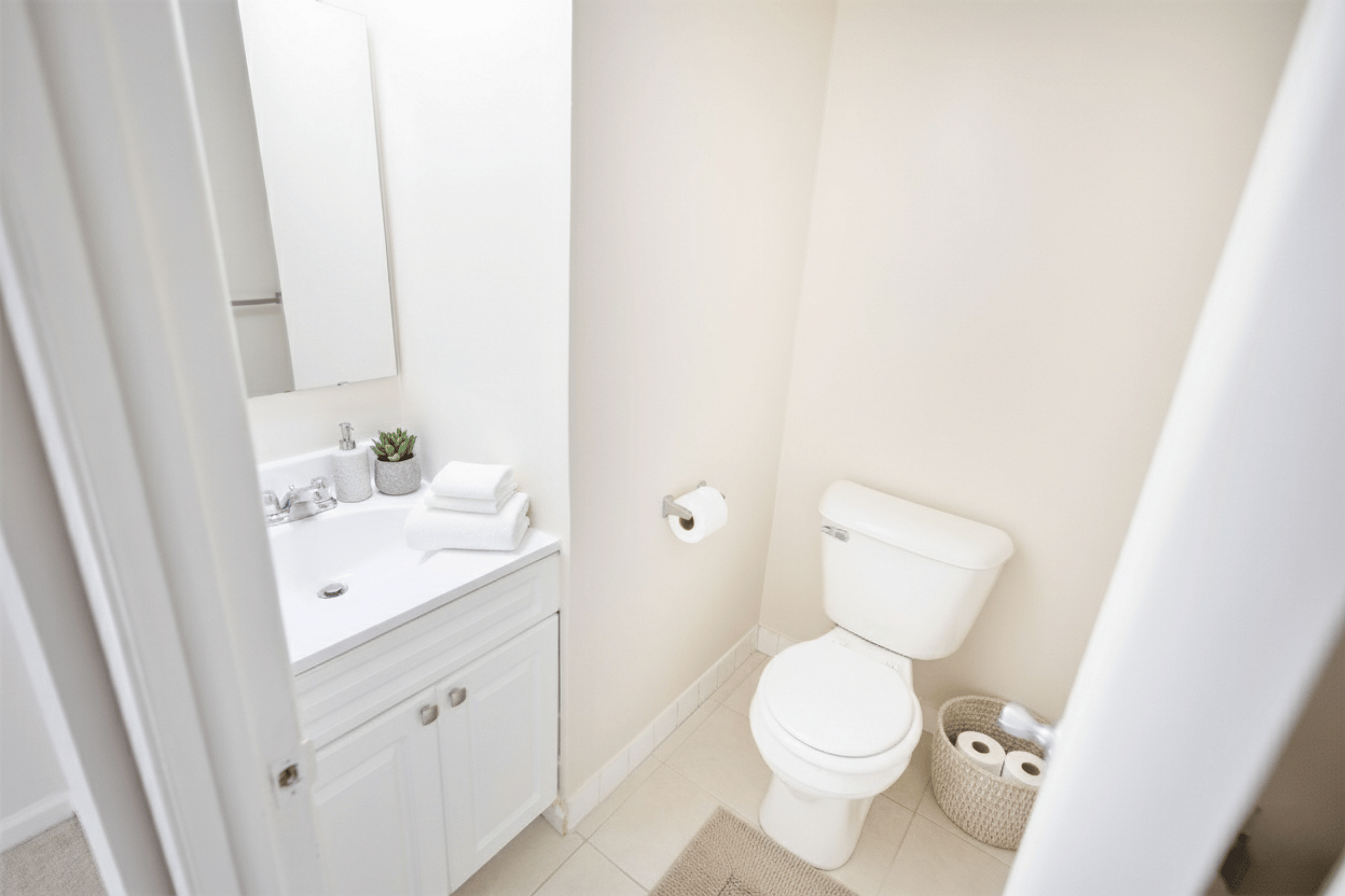 Bright and modern bathroom with elegant white fixtures, a stylish vanity, and cozy accents.