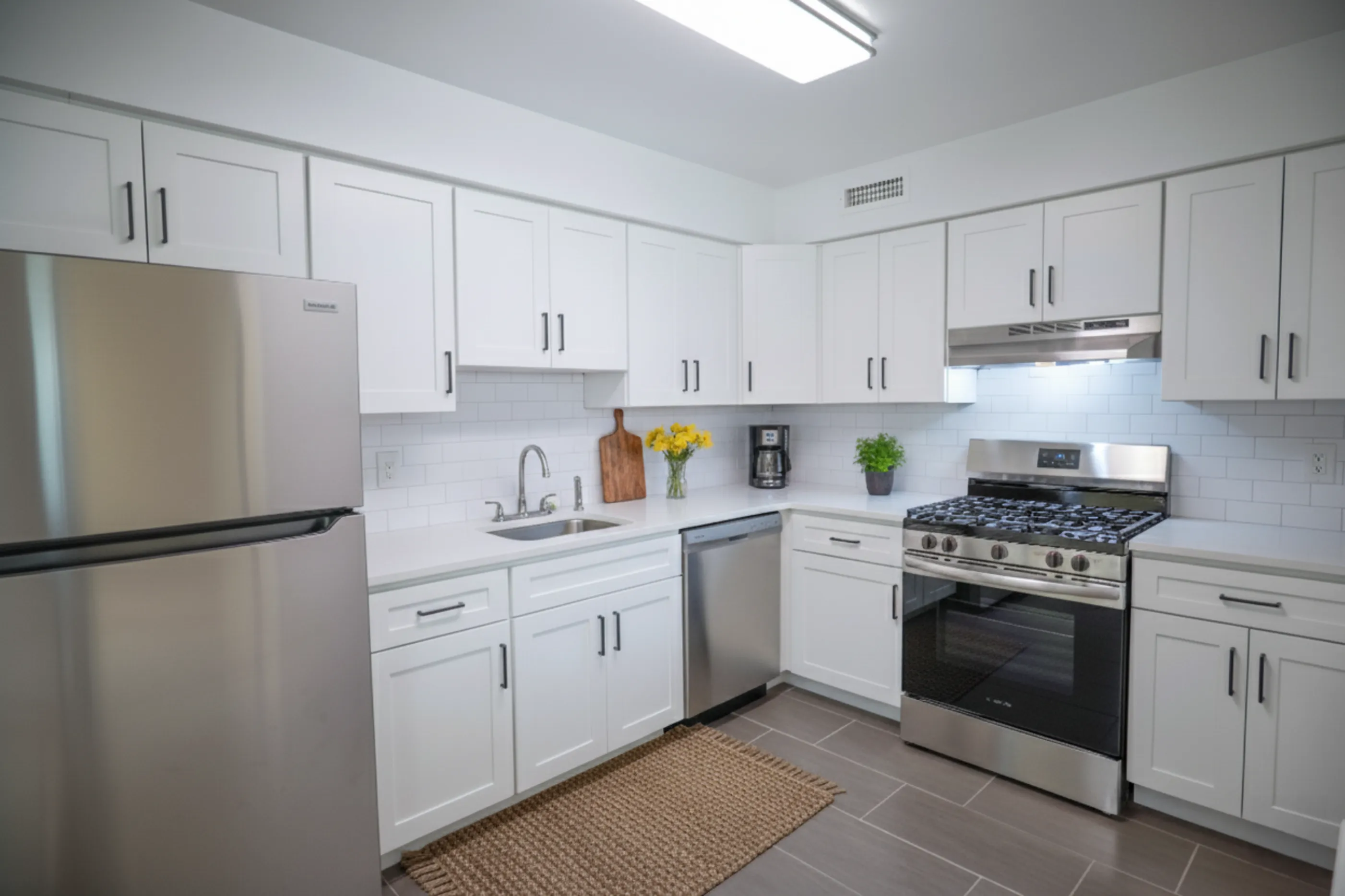 Bright, modern kitchen with sleek white cabinetry, stainless steel appliances, and elegant subway tile backsplash.