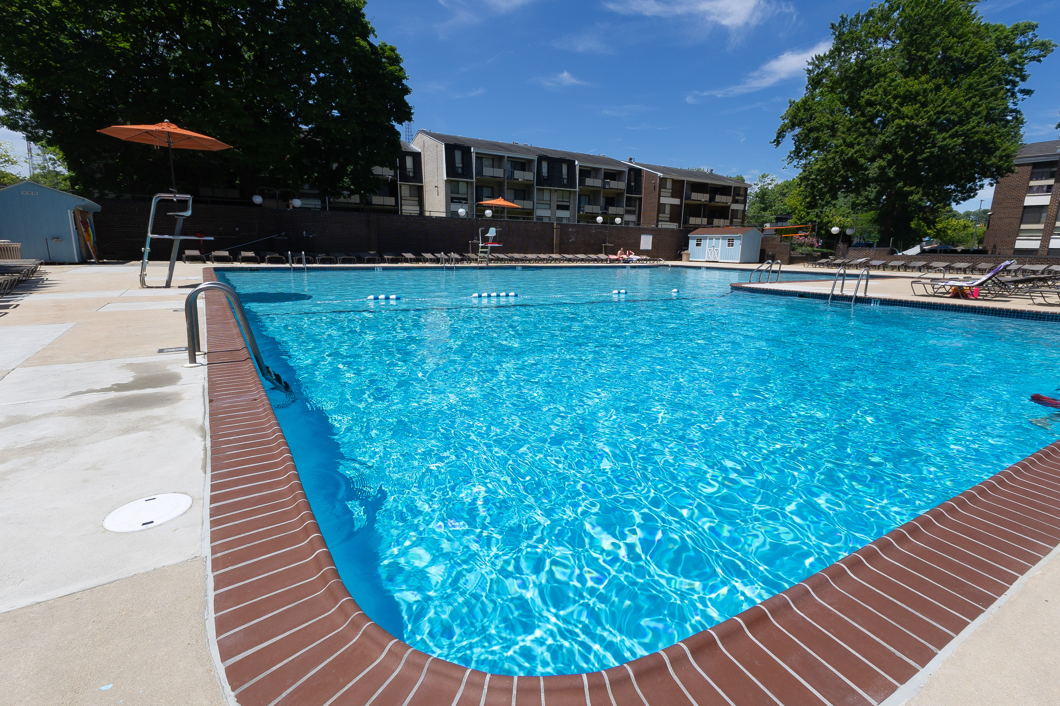 Inviting outdoor pool with crystal clear water and surrounding lounge chairs, perfect for relaxation and enjoyment on a sunny day.