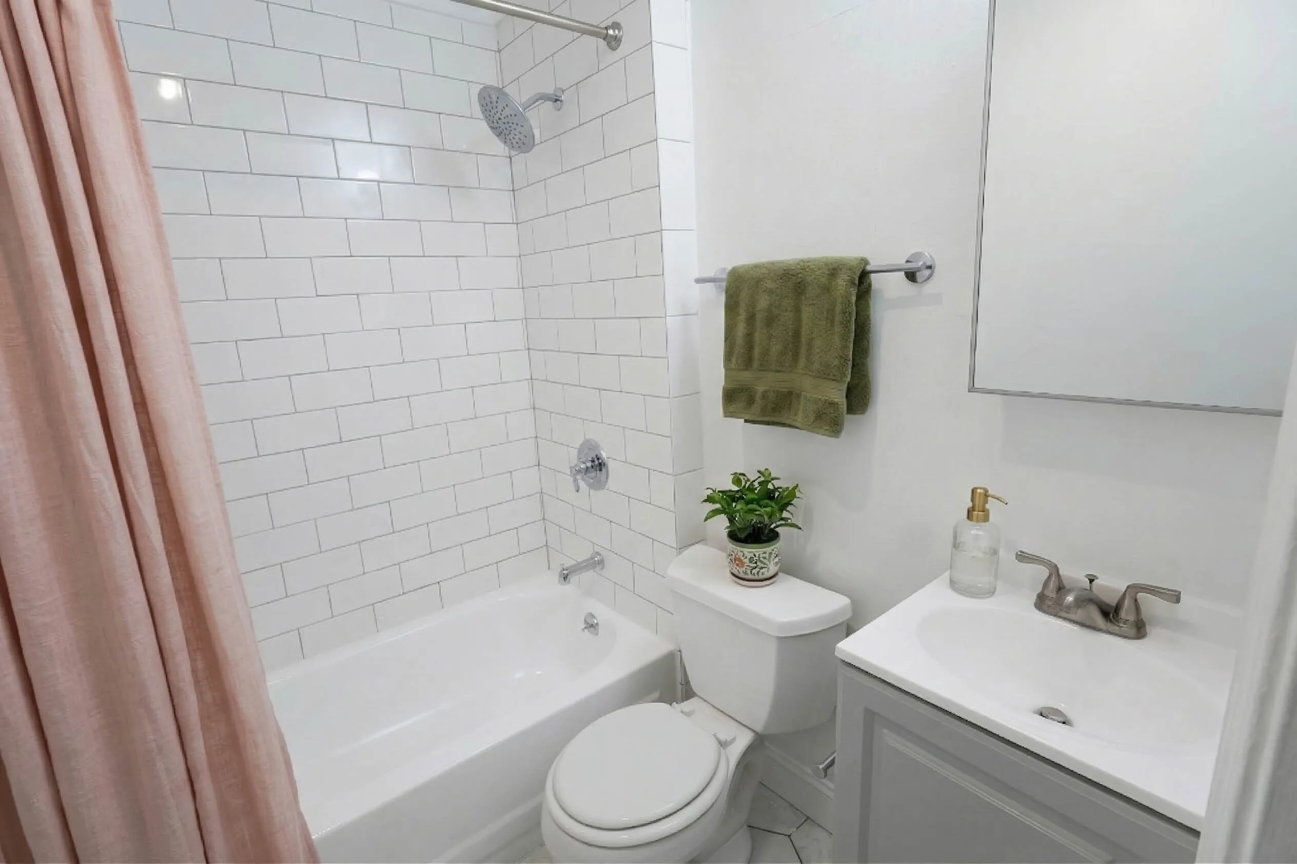 Bright, contemporary bathroom showcasing elegant white tile and a tasteful blend of green and pink accents.