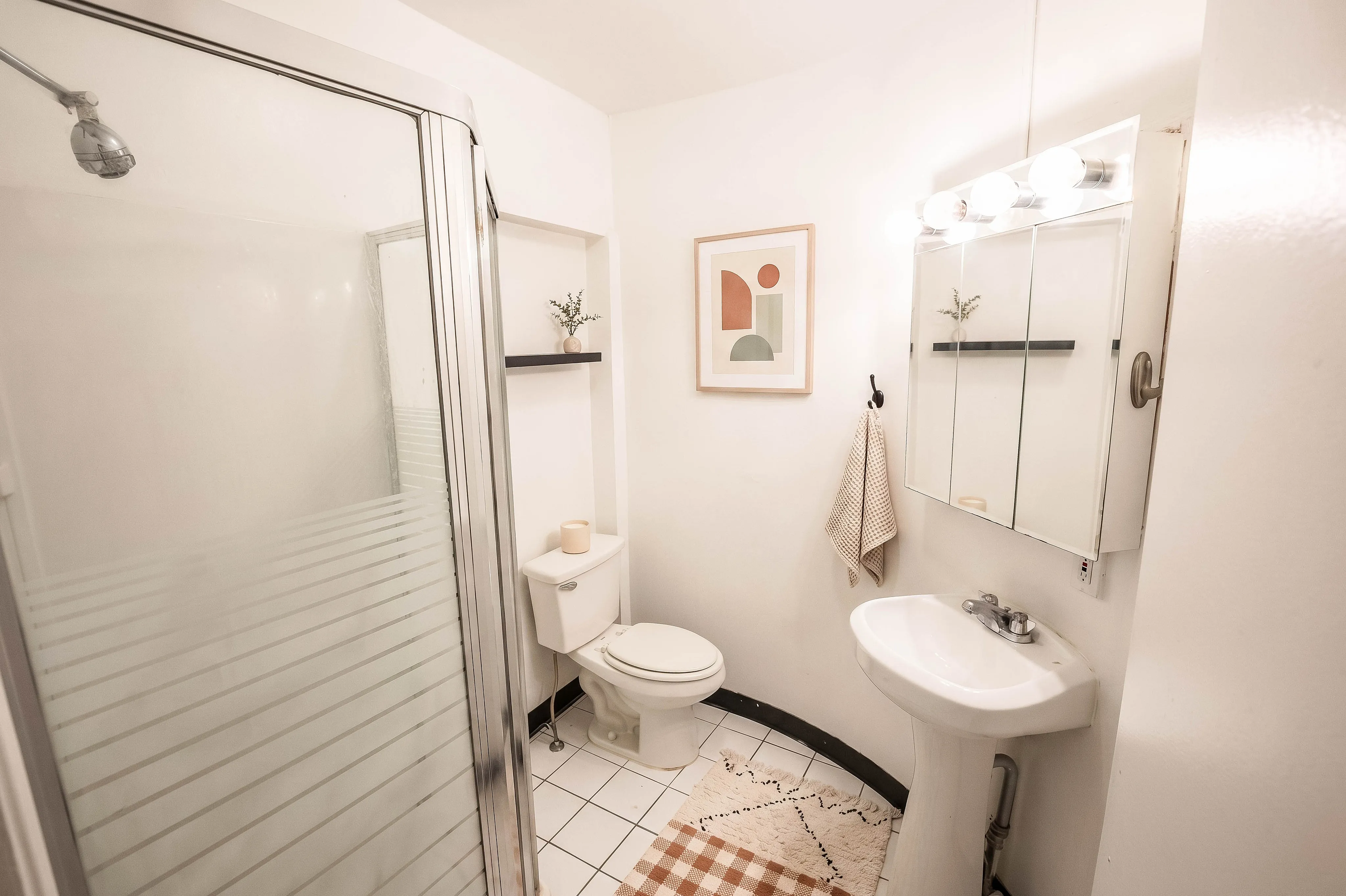 Bright, modern bathroom with sleek shower enclosure, stylish vanity, and tasteful decor for a fresh and inviting atmosphere.