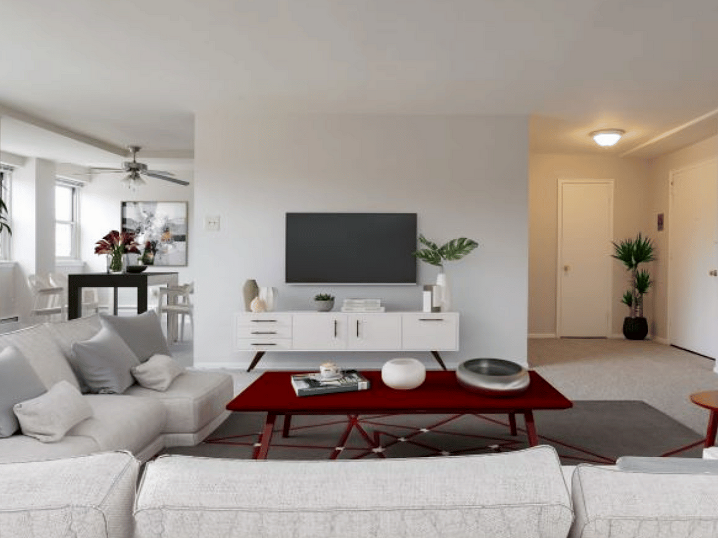 Chic living area with elegant modern decor, featuring a cozy white sofa, stylish red coffee table, and sleek entertainment unit.