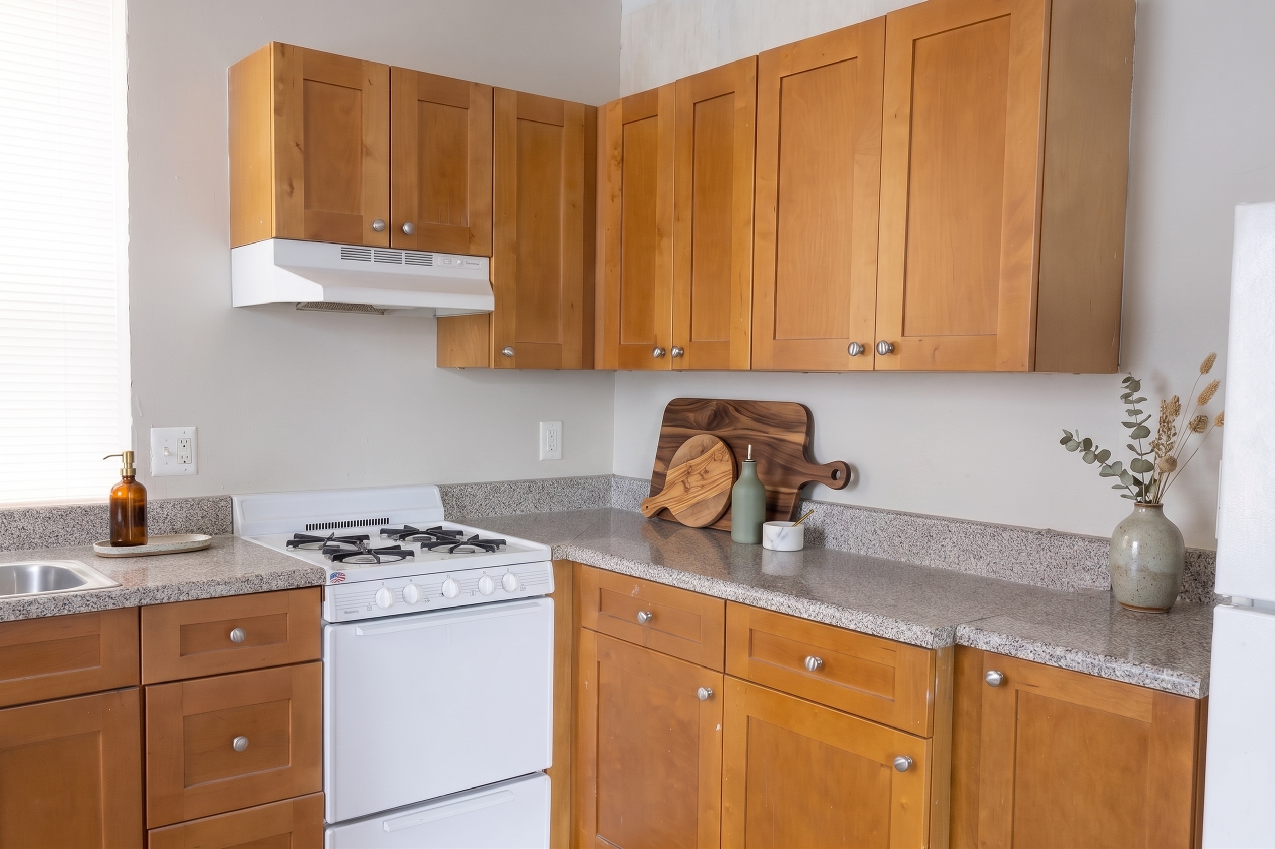 Charming kitchen featuring warm wood cabinets, sleek countertops, and a cozy stove, perfect for a welcoming home atmosphere.