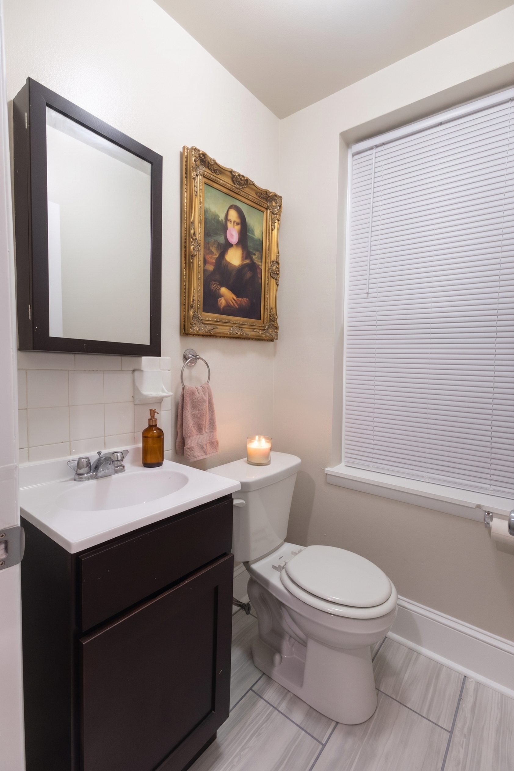 Chic bathroom with modern dark wood vanity, elegant wall art, and soft candlelight ambiance.