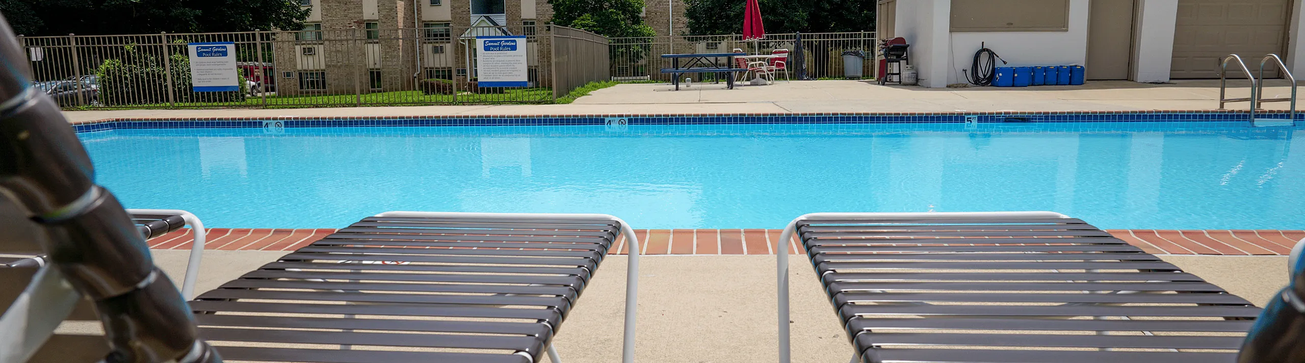 Inviting outdoor swimming pool with comfortable lounge chairs and lush greenery, perfect for relaxation and leisure.