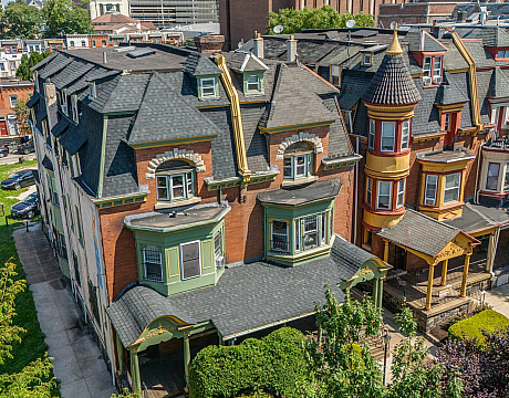 Charming Victorian-style row houses with ornate detailing and vibrant colors, nestled in a historic urban neighborhood.