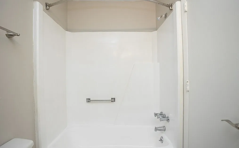 Modern bathroom featuring a sleek white bathtub and chrome fixtures, perfect for a refreshing retreat.