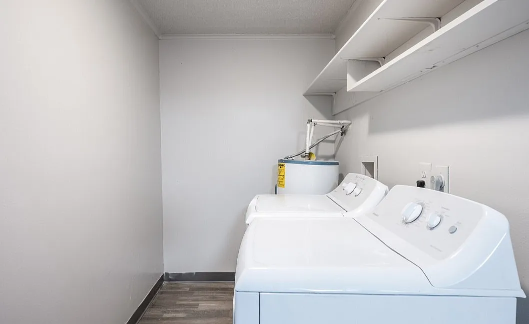 Bright, modern laundry room with efficient appliances and ample shelving space.