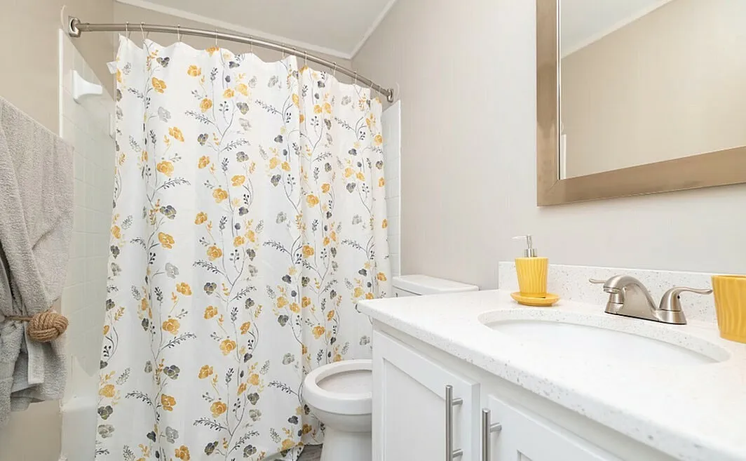 Bright and refreshing bathroom with floral shower curtain and modern vanity.