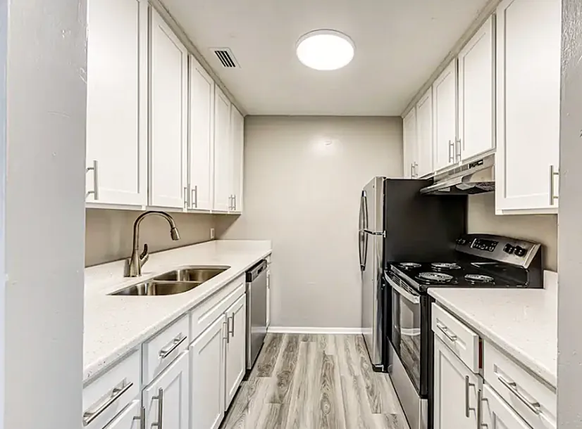 Sleek modern kitchen with white cabinetry, stainless steel appliances, and elegant countertops.