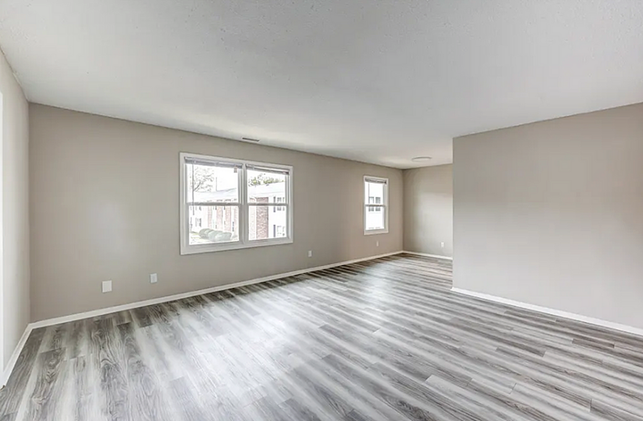 Bright and spacious living room with modern wood flooring and large windows offering abundant natural light.