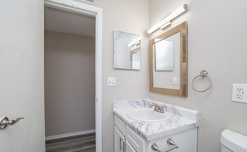 Contemporary bathroom with sleek marble countertop and elegant lighting, offering a modern touch.