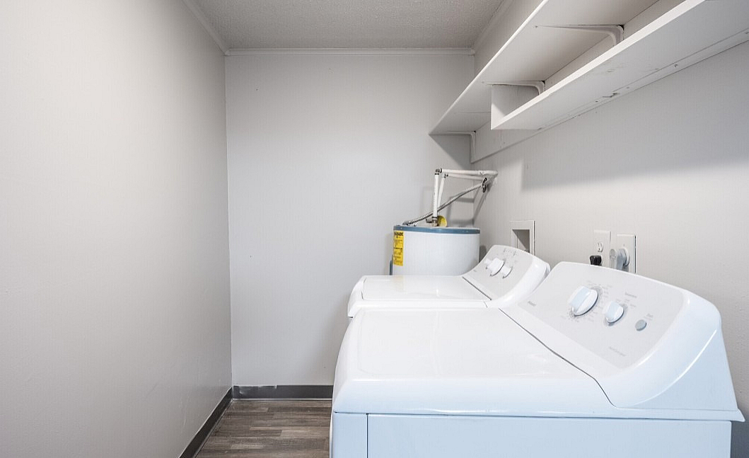 Modern laundry room featuring a sleek washer and dryer, with ample shelving and efficient layout for convenience.
