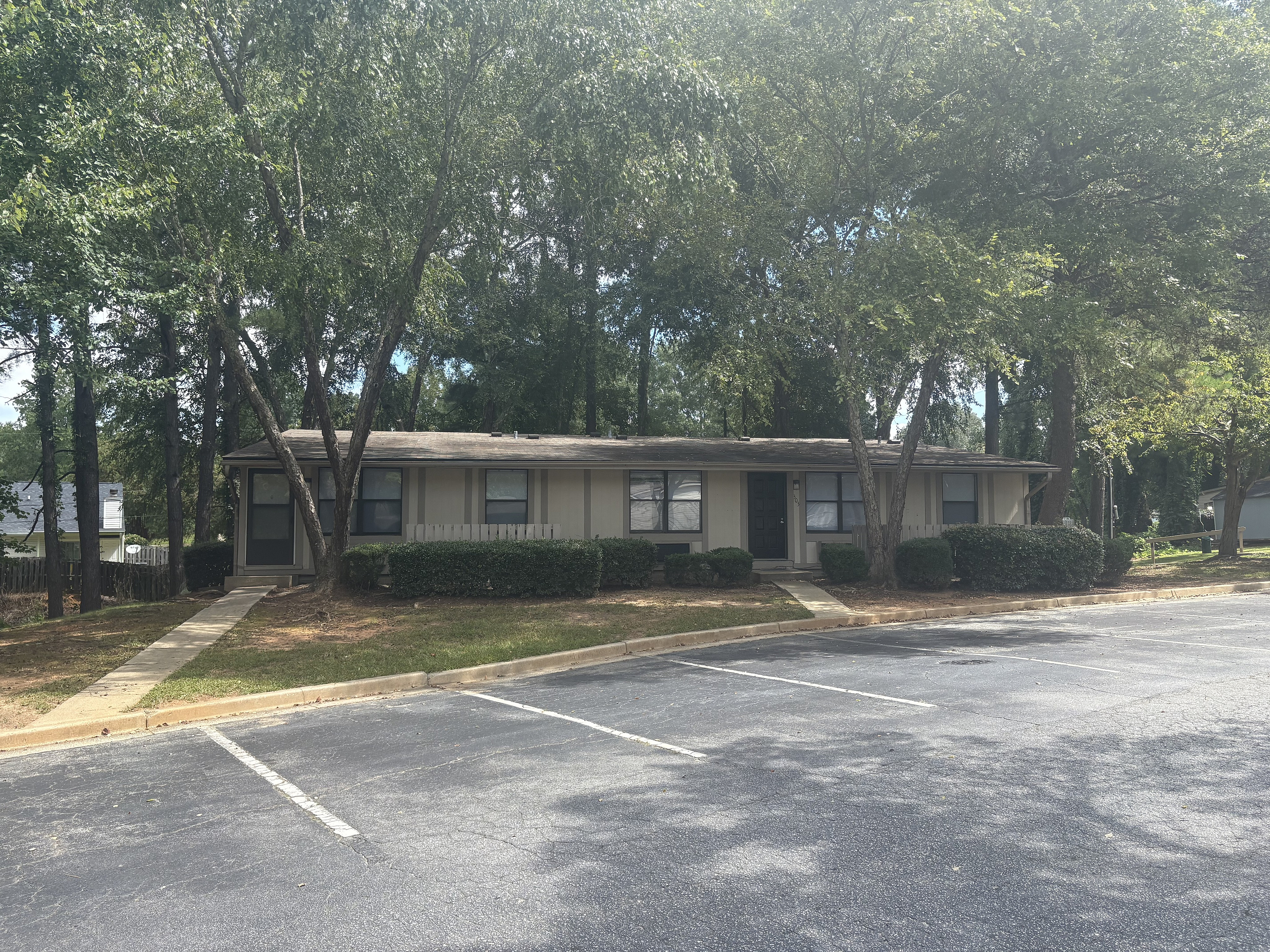 Charming suburban home surrounded by lush greenery and peaceful wooded area, featuring a classic exterior design.