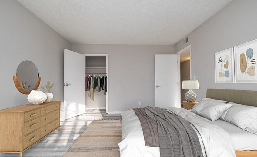 Bright and modern bedroom with a cozy bed, chic wooden dresser, stylish decor, and spacious walk-in closet.