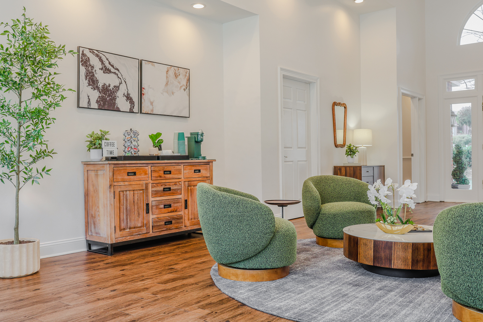 Inviting clubhouse living area featuring stylish green chairs, elegant wood furnishings, and modern artwork. Creating a cozy yet sophisticated ambiance ideal for relaxing or socializing