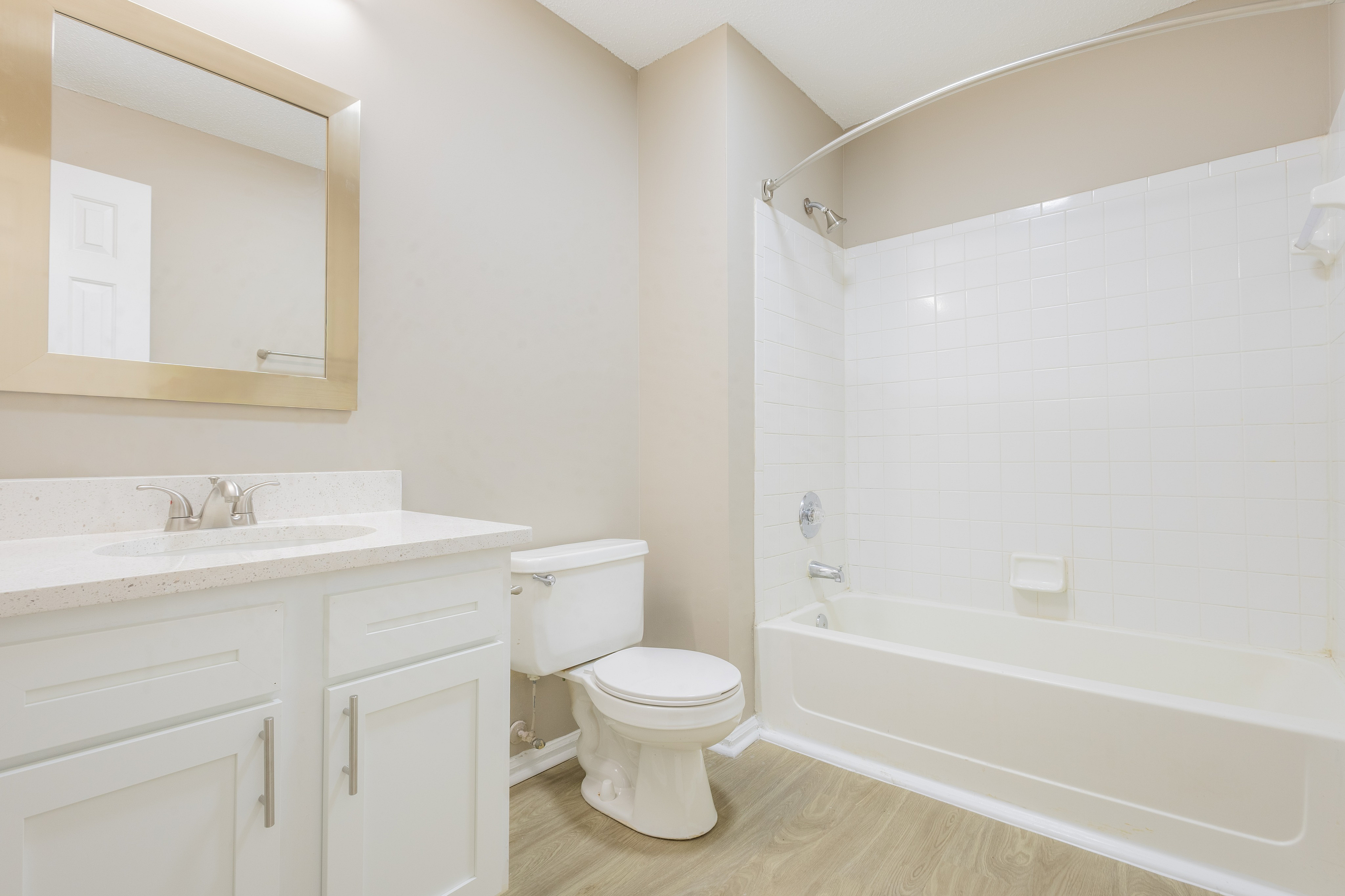 Bright, modern bathroom with a sleek vanity, large mirror, and a pristine bathtub.