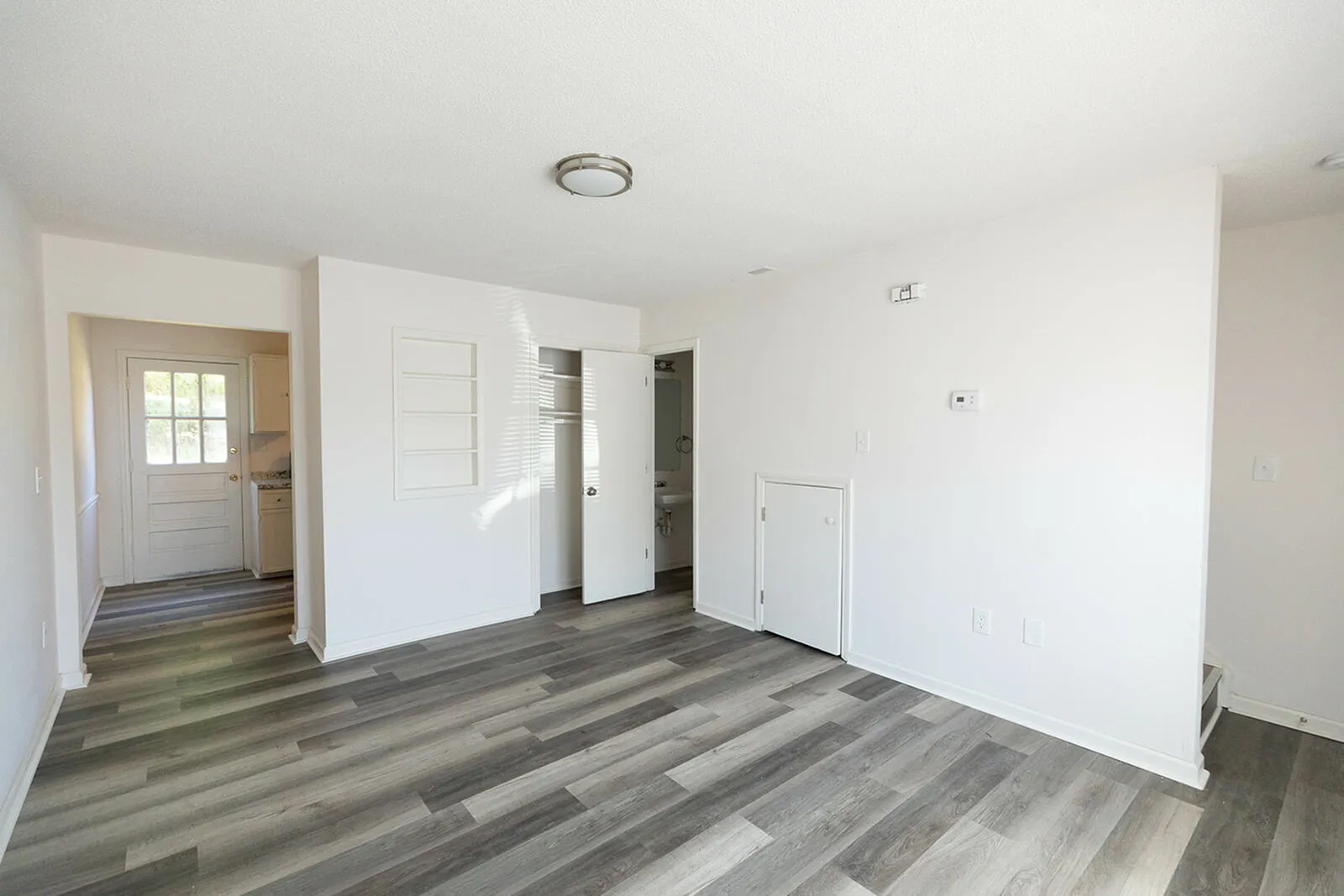 Bright and modern open-plan living area featuring sleek wood flooring and abundant natural light.