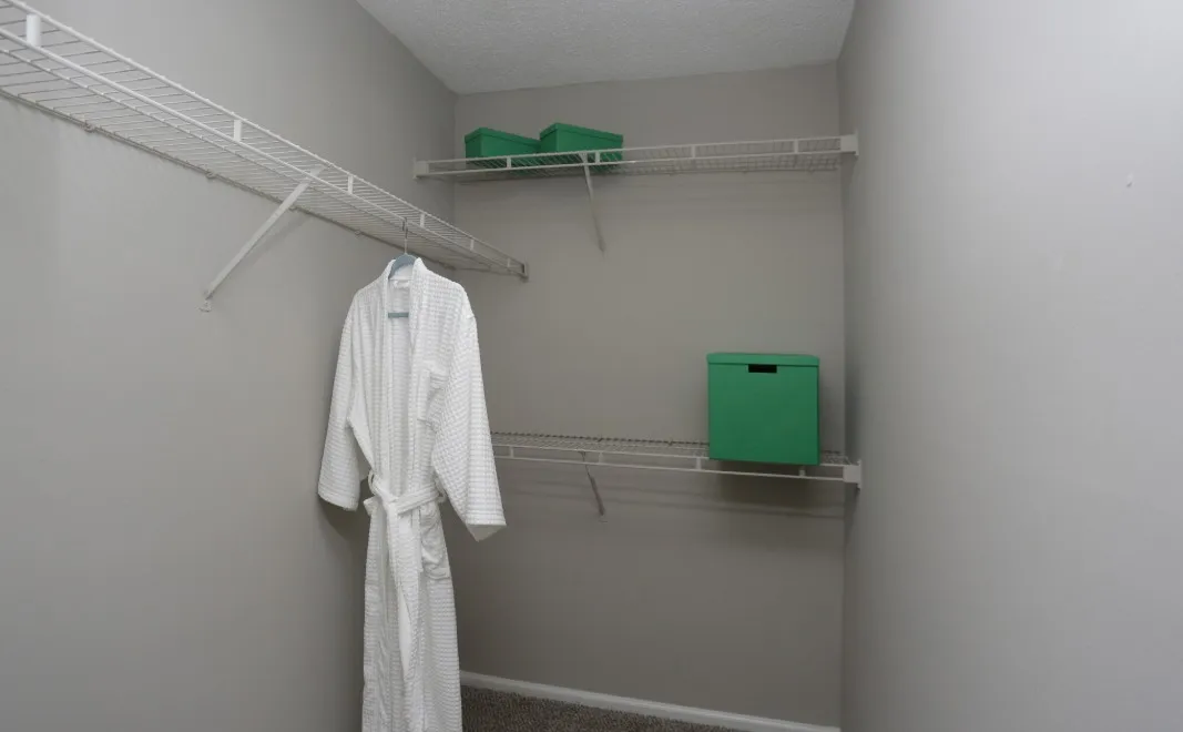 Spacious walk-in closet featuring organized shelving and a plush robe, ideal for stylish storage.