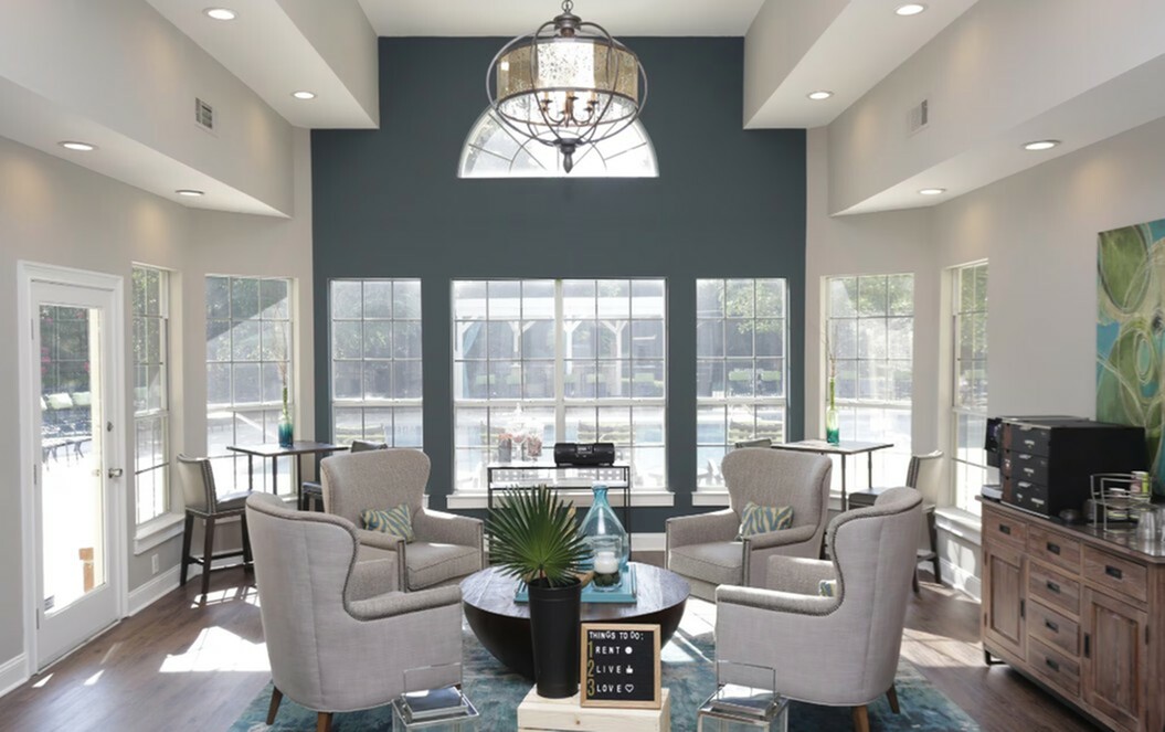 Bright and inviting living room with modern armchairs, large windows, and elegant decor, offering a cozy and stylish atmosphere.