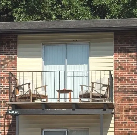 Charming brick apartment balcony with cozy seating and scenic views, perfect for relaxation and outdoor enjoyment.