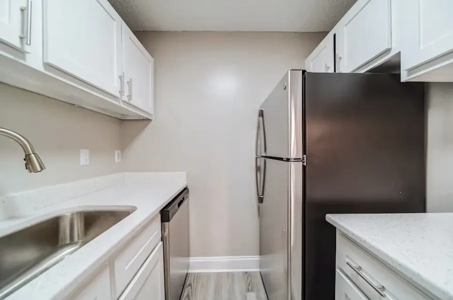 Modern kitchen with sleek stainless steel appliances, elegant white cabinetry, and stylish countertops offering ample space.