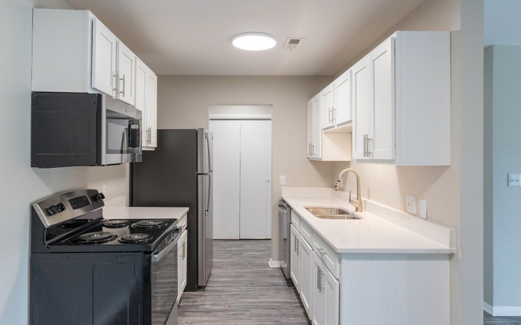 Sleek modern kitchen with stainless steel appliances, pristine white cabinetry, and elegant countertops, perfect for culinary inspiration.