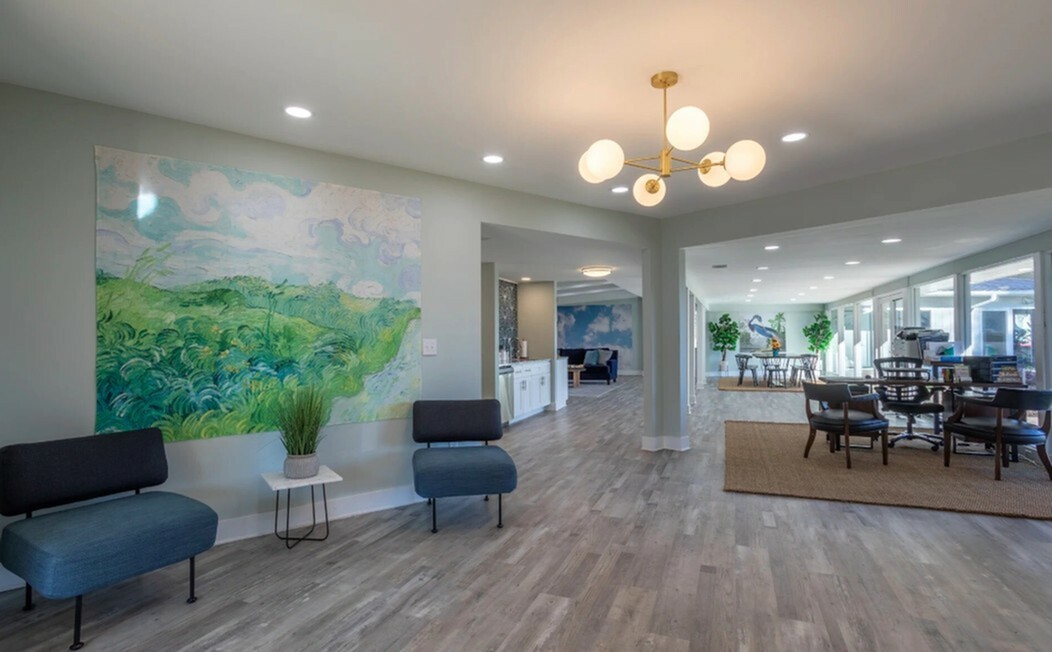 Modern apartment interior with elegant lighting, stylish seating, and vibrant artwork creating an inviting atmosphere.