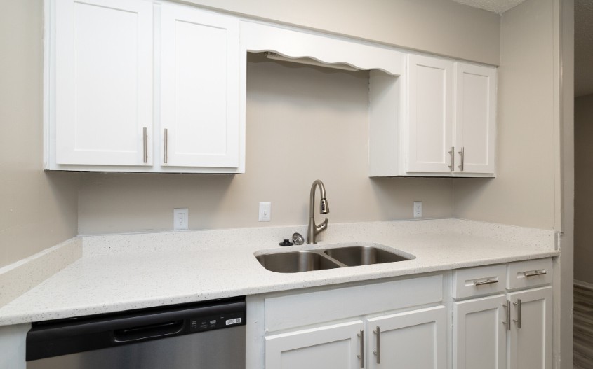 Modern kitchen with sleek white cabinets, spacious countertops, and stainless steel appliances for a chic culinary experience.