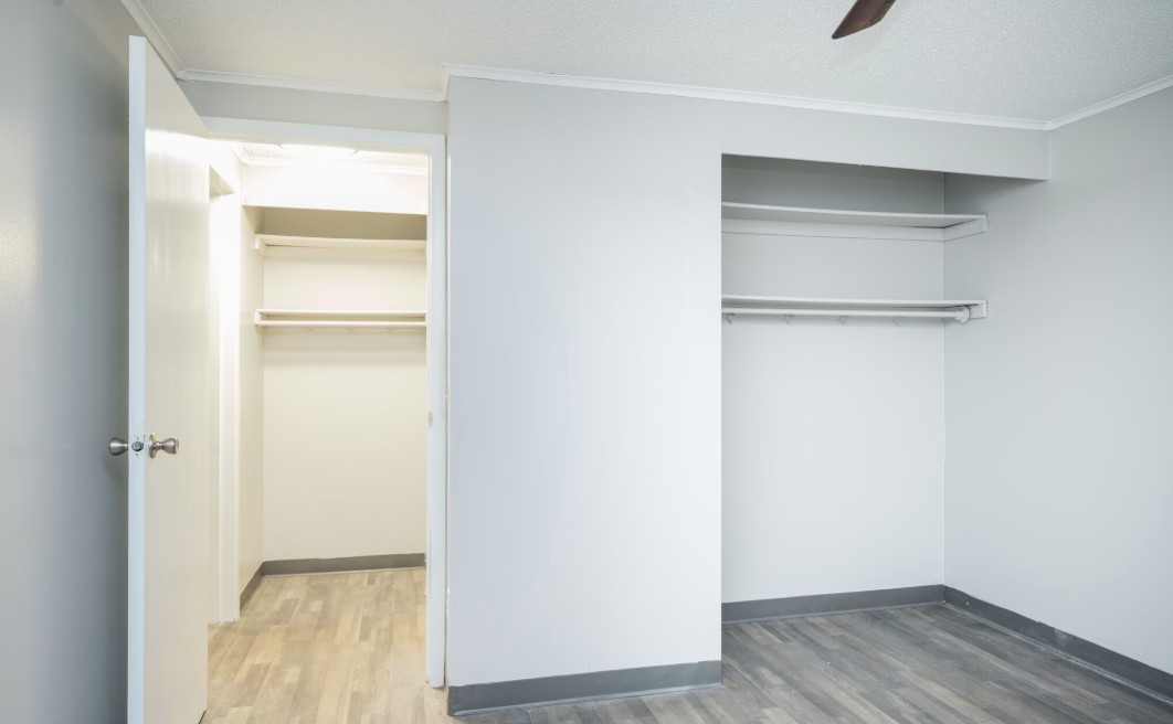 Bright, spacious walk-in closet with sleek shelving and modern flooring, perfect for stylish storage solutions.