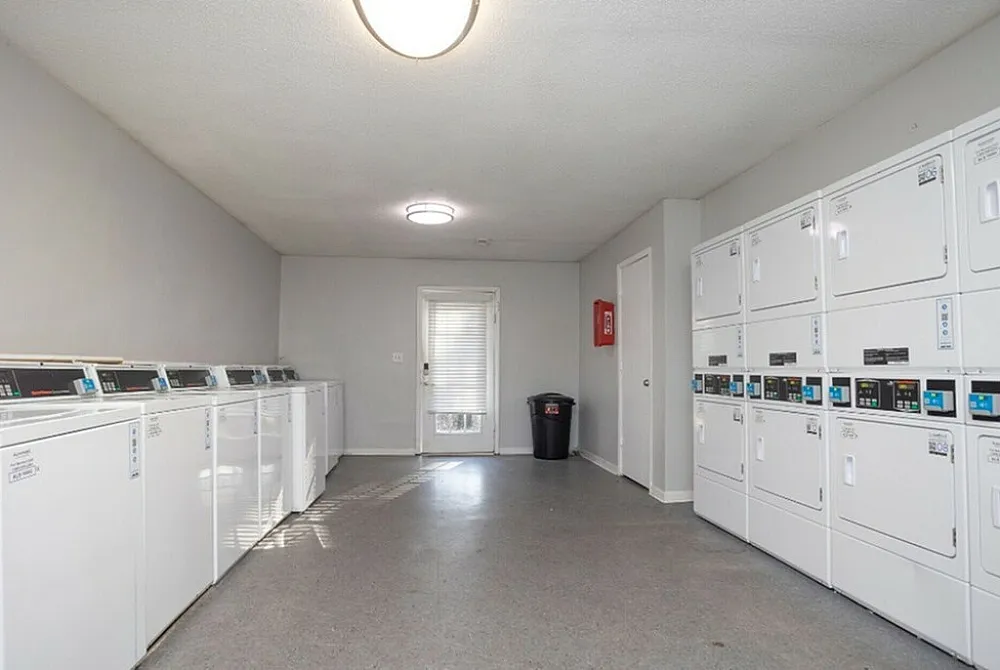 Bright and spacious laundry room featuring modern washing machines and dryers, perfect for convenient living.