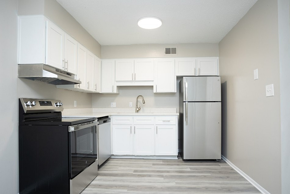 Modern kitchen with sleek stainless steel appliances, ample white cabinetry, and stylish flooring for a contemporary look.