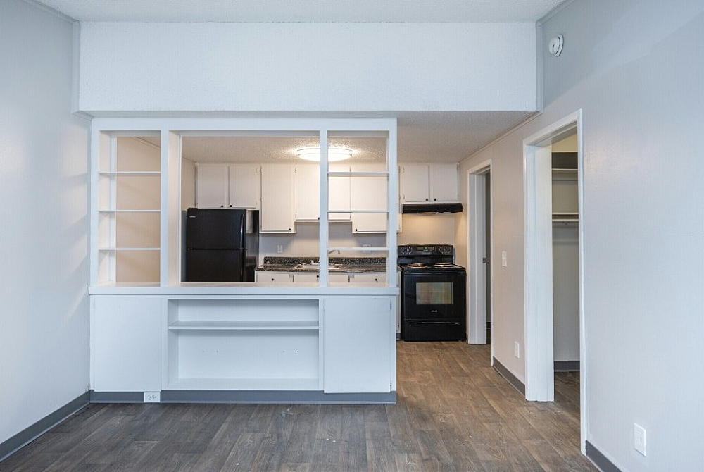 Bright, modern kitchen space with sleek white cabinetry, open shelving, and contemporary appliances.