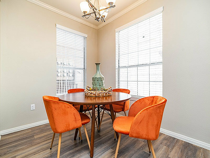 Bright and inviting dining area with chic orange chairs and elegant decor, perfect for vibrant gatherings.