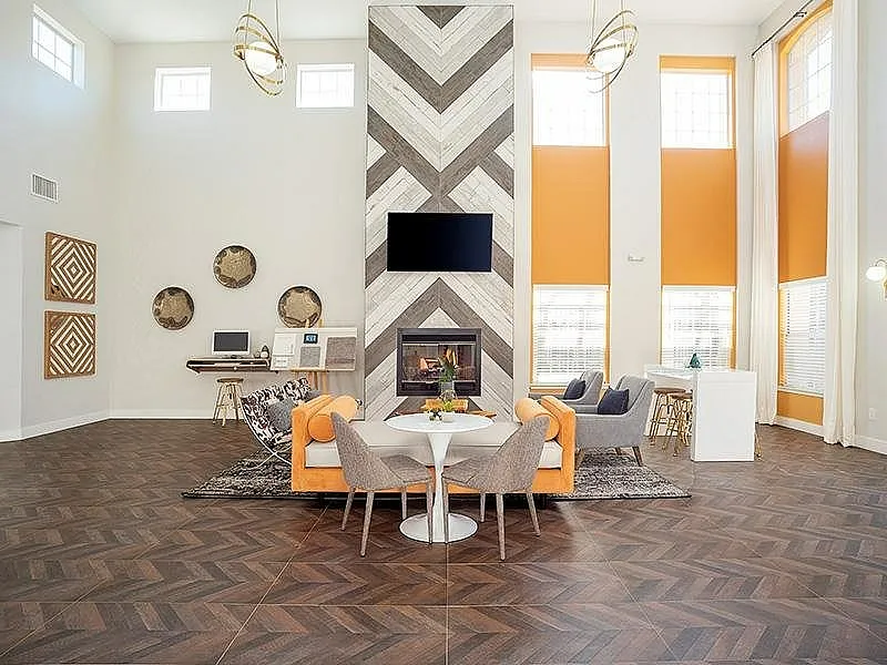Sophisticated living area with high ceilings, a modern fireplace, and stylish seating, perfect for relaxation and entertaining.