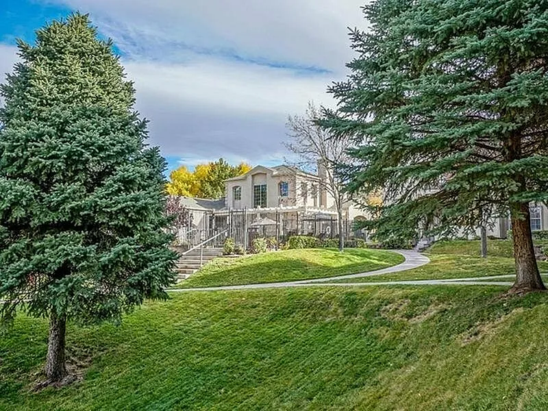 Charming residence surrounded by lush greenery, featuring a beautifully landscaped yard and mature trees in a tranquil setting.