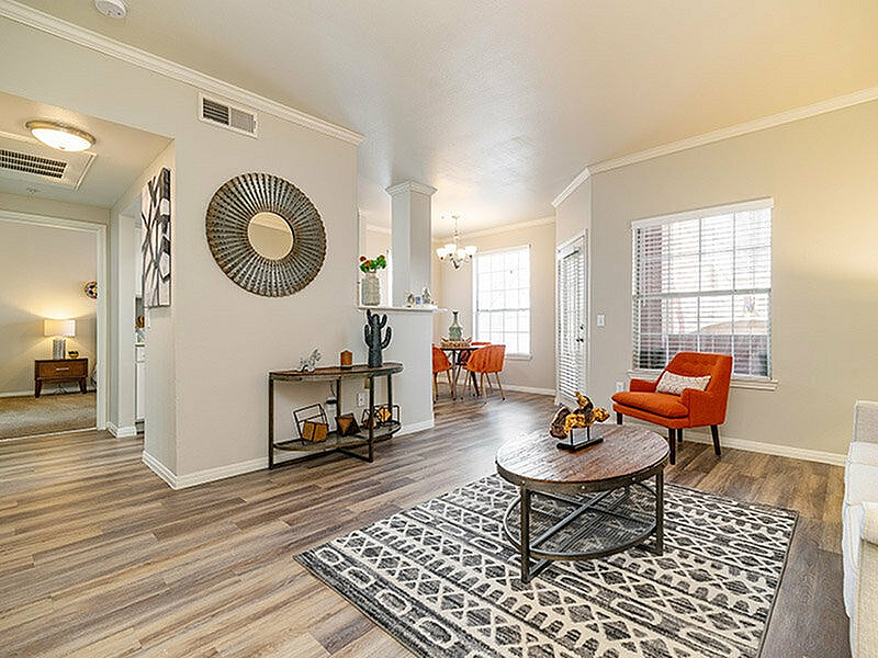 Bright, inviting living room showcasing elegant hardwood floors, modern furniture, and abundant natural light.
