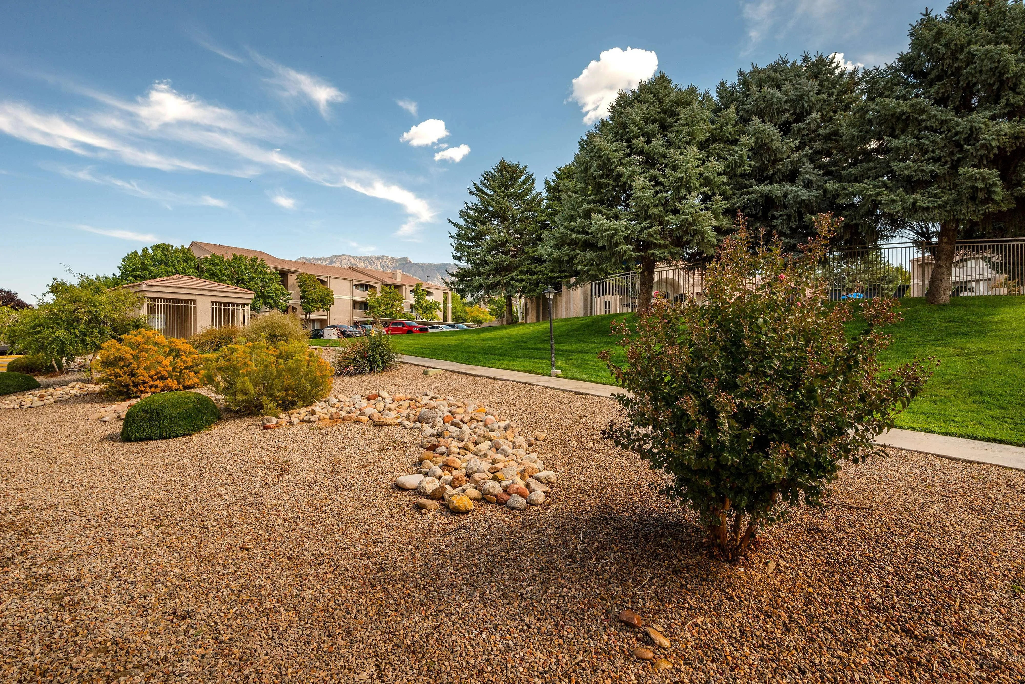 Charming landscaped outdoor area with lush greenery and scenic mountain views, perfect for tranquil living.