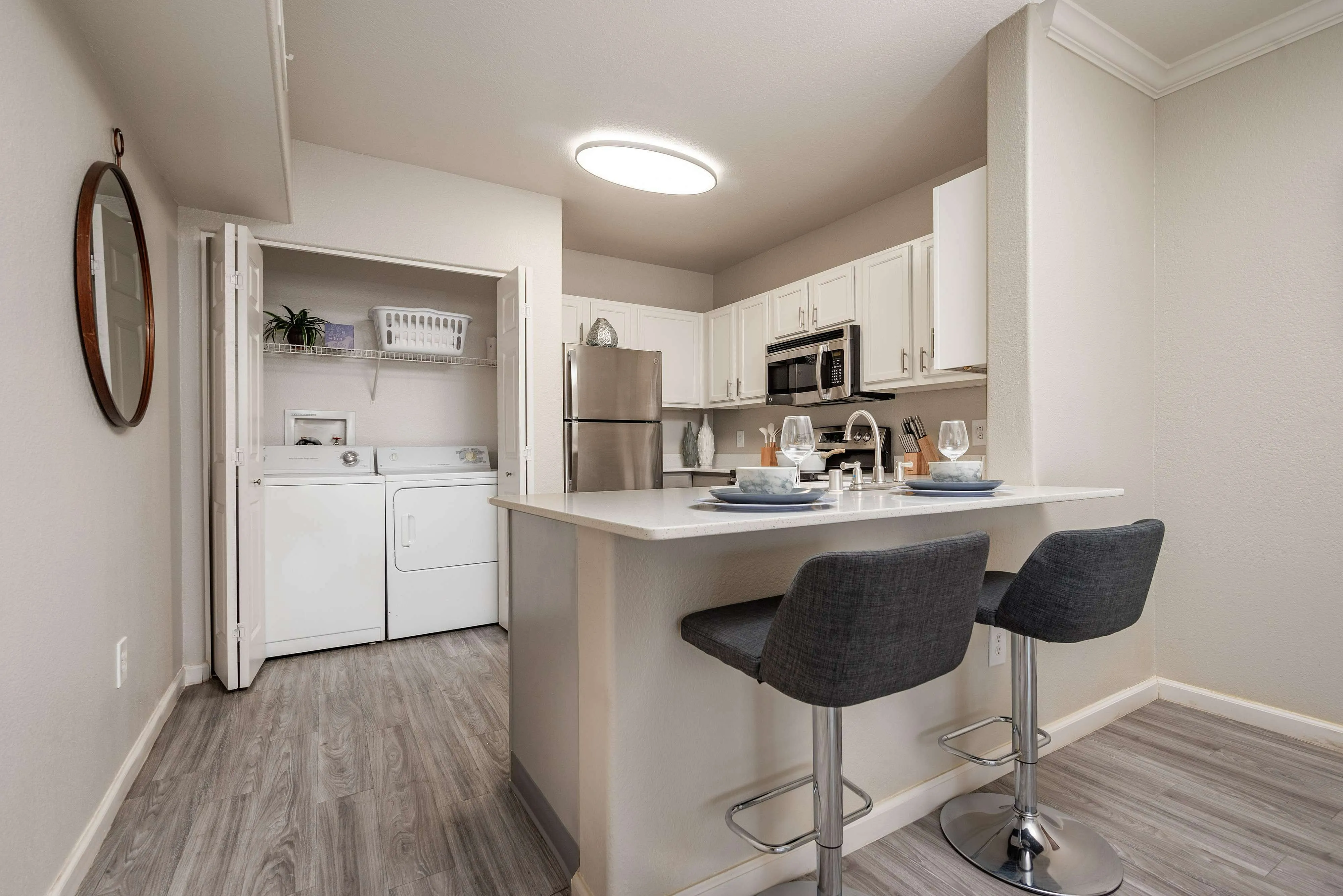 Chic apartment kitchen with modern appliances, elegant breakfast bar, and in-unit laundry for comfortable living.