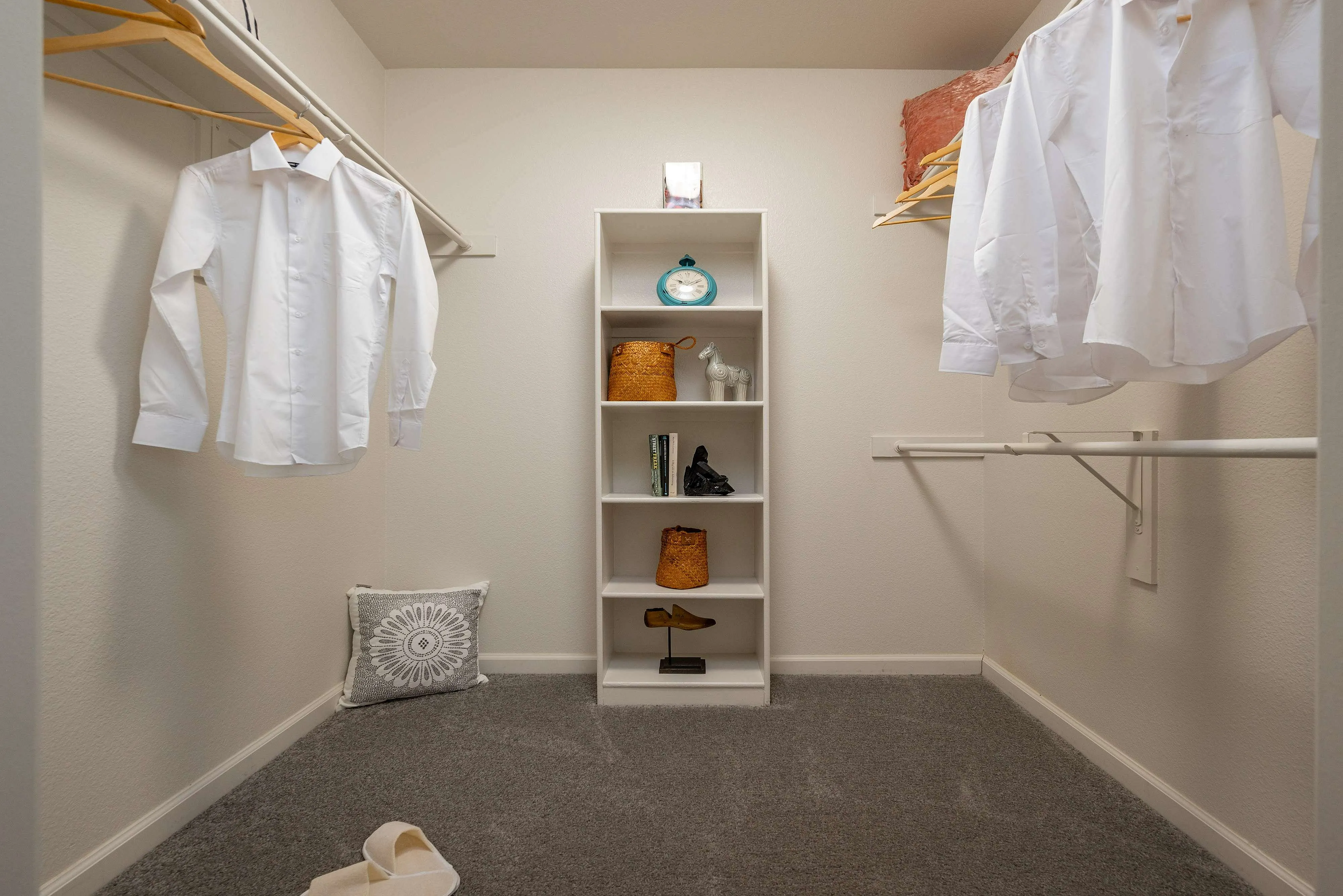 Spacious walk-in closet with elegant shelving and hanging space, showcasing a neat and organized layout ideal for ample storage.