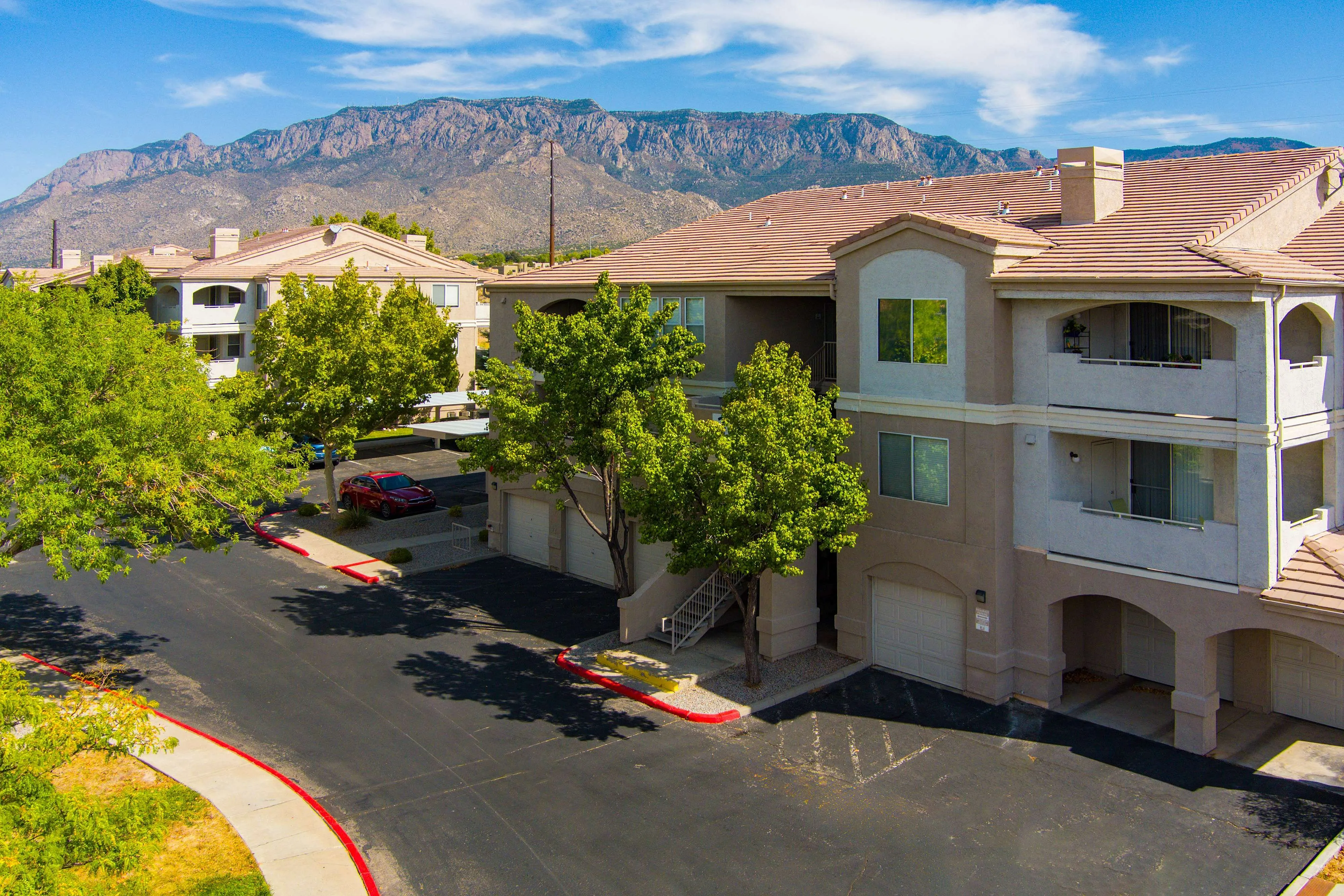 Beautiful apartment building surrounded by lush greenery with scenic mountain views, offering a peaceful suburban lifestyle.
